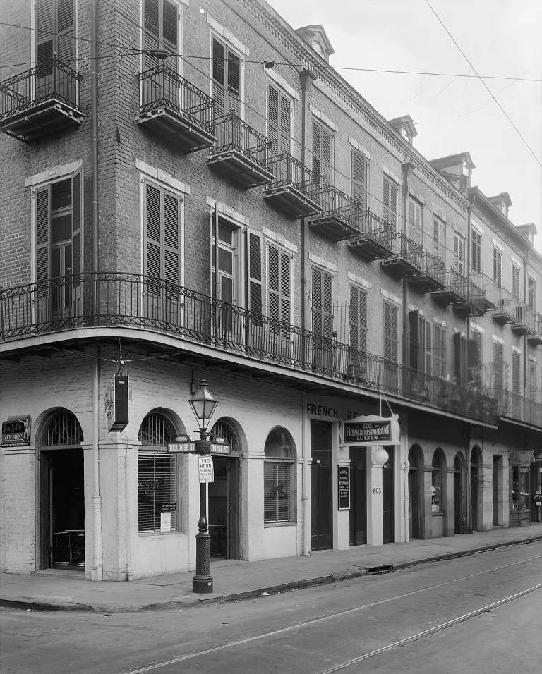 Black-and-white view of historic buildings with shuttered windows and decorative ironwork balconies on Royal Street in New Orleans.